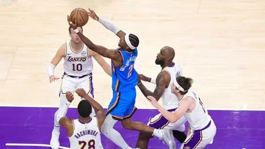 Los Angeles Lakers players collapse on Oklahoma City Thunder guard Shai Gilgeous-Alexander (2) during an NBA playoff game on May 9, 2026 in Los Angeles, CA.